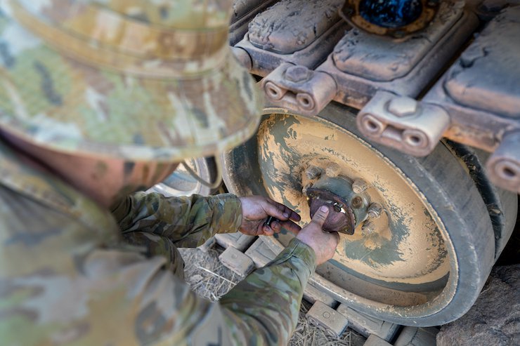 SPEE3D-Bradshaw_6911_AMcell soldier installing SPEE3D printed Wheel Bearing part on M113.jpg